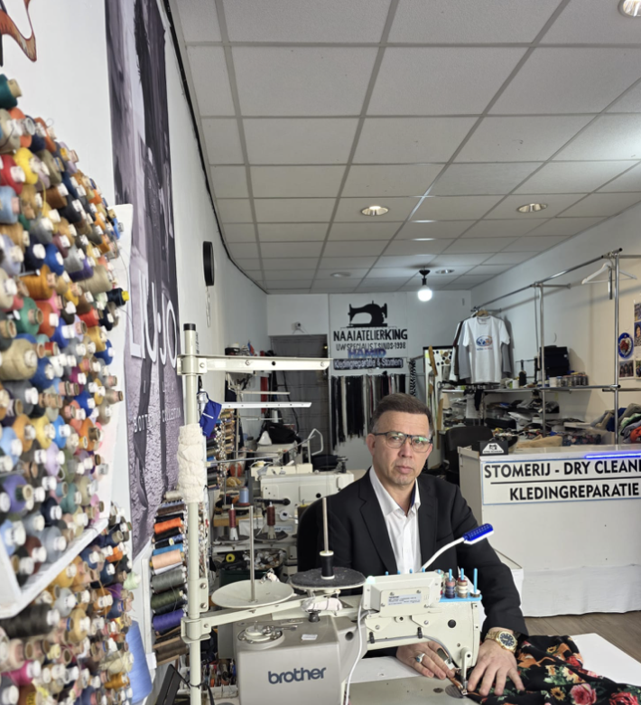 Hamid aan het werk achter zijn naaimachine